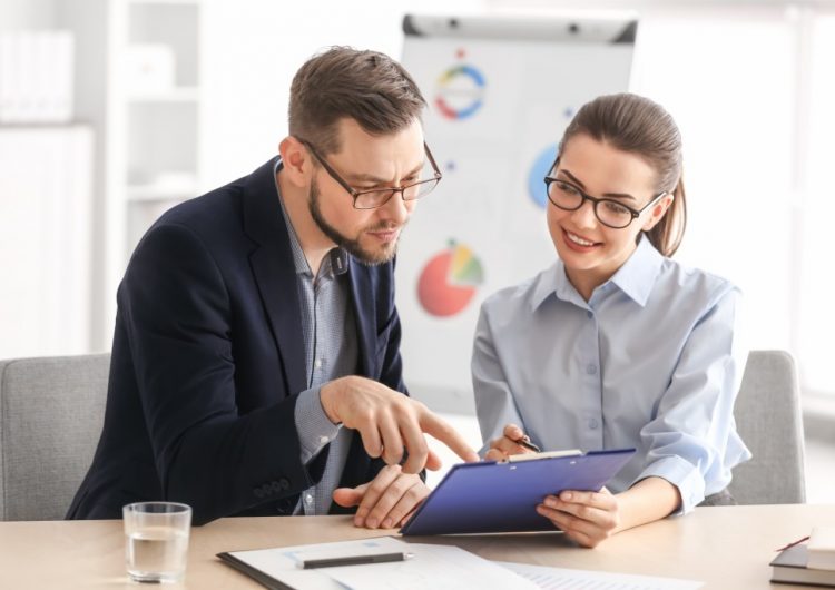 business man and woman looking at the clipboard
